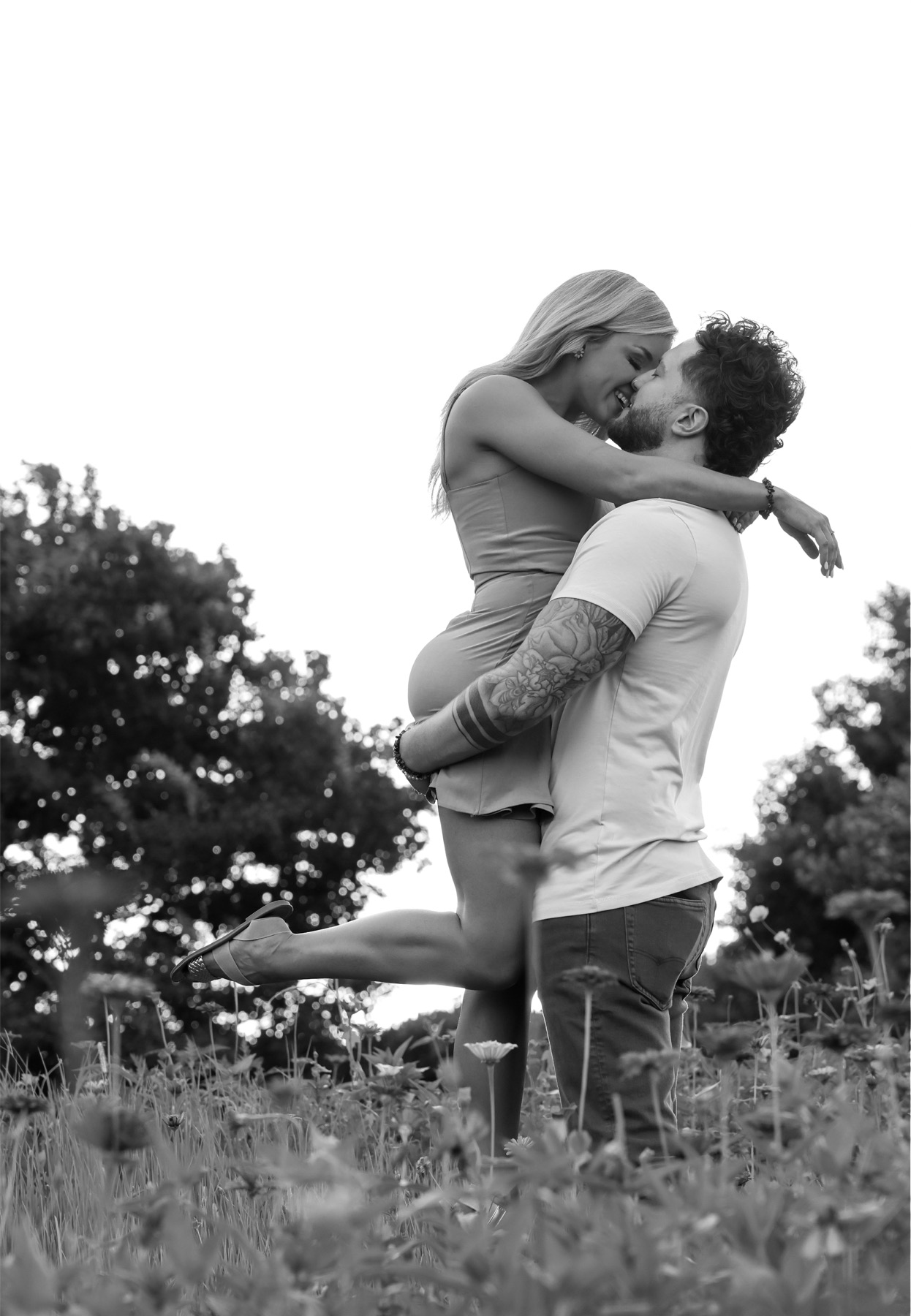 Black and white: a lift and a kiss in the tall grass.