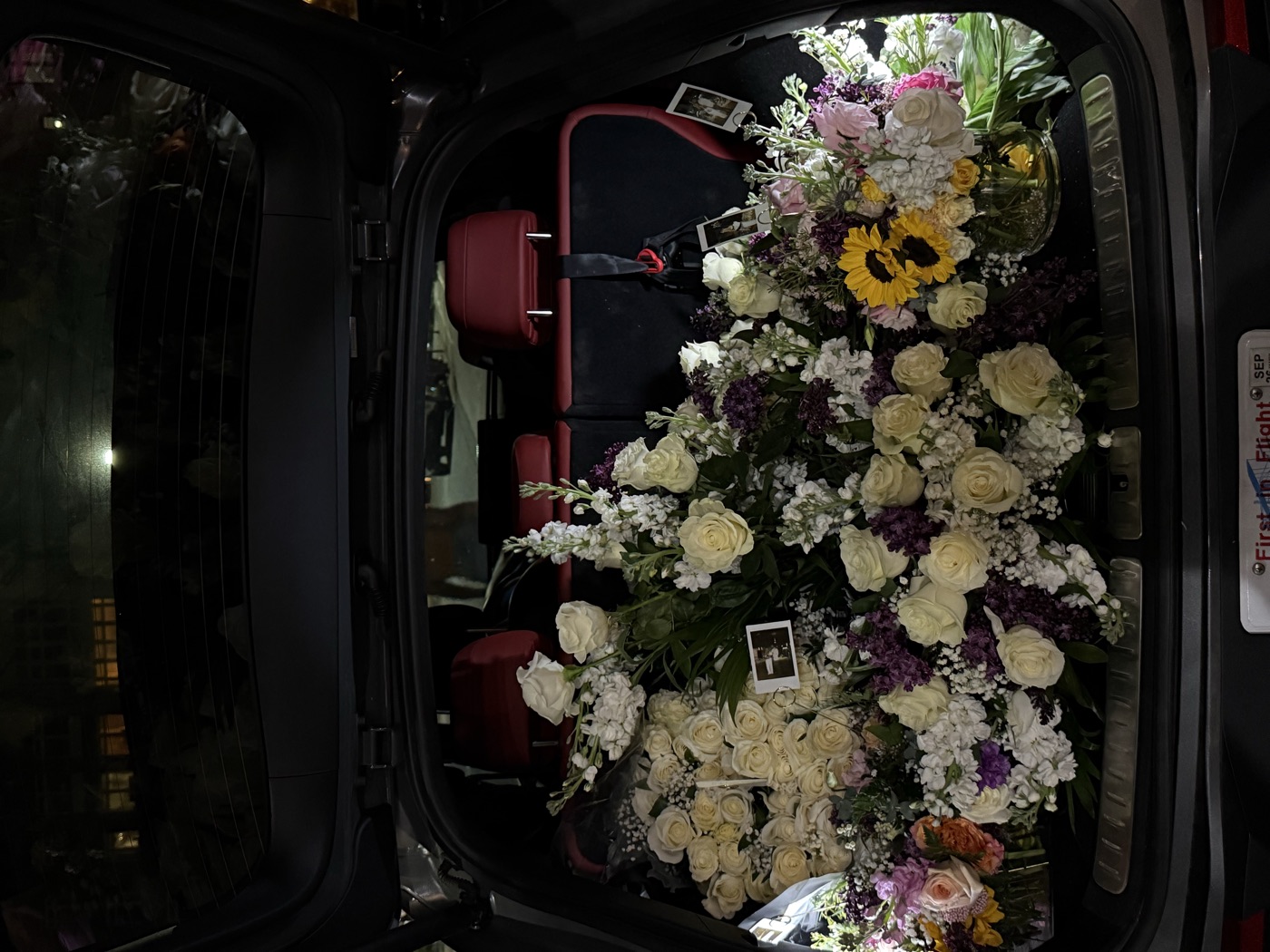 A car trunk completely filled with the 59 bouquets and the 60 white roses, the night before the proposal.