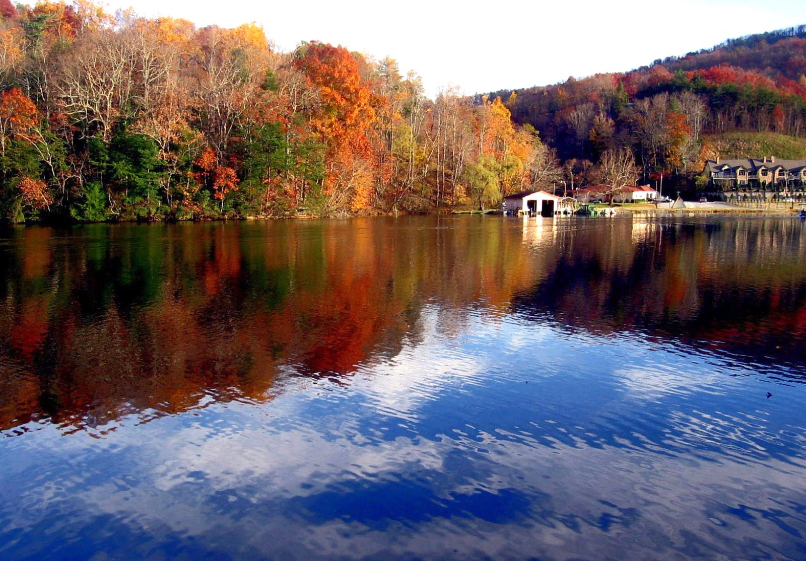 Fall color and sky mirrored in the still water of Lake Lure.
